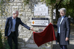 Bild vergrößern: Bürgermeisterin Dorothea Deneke-Stoll und Reinhard Rauscher, Leiter des Bestattungsamts, enthüllen das neue Schild.