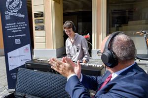 Bild vergrößern: »Silent Playground« - eine Aktion von der Kunst und Kultur Bastei e.V.: Gabriel Kobulashvili spielt auf dem E-Piano mit zwei Noise-Cancelling-Kopfhörern. Je einer für den Pianisten und den Passanten, der sich mitten in der Innenstadt ein Privatkonzert anhören kann. Dabei wird natürlich auch auf Hygiene geachtet. Es gibt Einmal-Schützer für die Kopfhörer und auch die Hände müssen desinfiziert werden, bevor die Kopfhörer angefasst werden